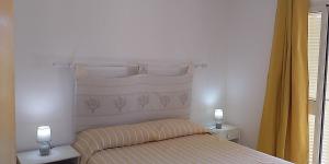 a bedroom with a bed and two lamps on two tables at Casa Marconi in San Teodoro +3 photos