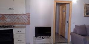 a kitchen with a flat screen tv in a living room at Casa Marconi in San Teodoro