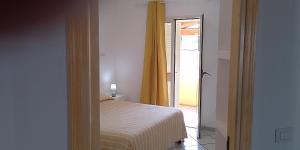 a bedroom with a bed and a door to a patio at Casa Marconi in San Teodoro