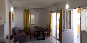 a living room with a table and a chair at Casa Marconi in San Teodoro