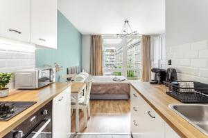 Una cocina y una sala de estar con una cama al fondo. en Charming Apartment in the City Center, en Varsovia