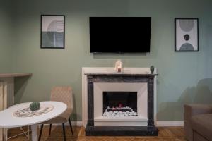 a living room with a fireplace with a flat screen tv at Loreto Prestige - Parking Free & Bulb Gym in Milan