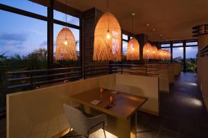 a restaurant with tables and chairs and lights at Glamday Style Okinawa Yomitan Hotel & Resort in Yomitan