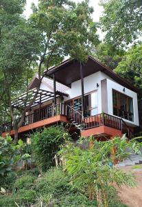 a small white house with a balcony and trees at Ocean View Mini-Villa in Wok Tum