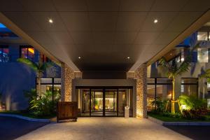 a lobby of a building with palm trees at Glamday Style Okinawa Yomitan Hotel & Resort in Yomitan