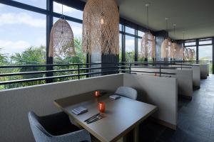 a restaurant with a table and chairs and windows at Glamday Style Okinawa Yomitan Hotel & Resort in Yomitan