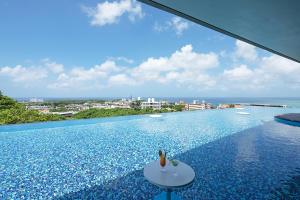 a swimming pool with a view of the ocean at Glamday Style Okinawa Yomitan Hotel & Resort in Yomitan