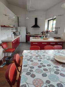 a kitchen with a table and red chairs and a kitchen with a table at Loft au piémont des Pyrénées Cathares in Sainte-Colombe-sur-lʼHers