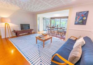 a living room with a blue couch and a table at Havehus in Denmark