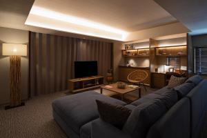 a living room with a couch and a television at Glamday Style Okinawa Yomitan Hotel & Resort in Yomitan
