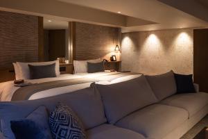 a bedroom with a large bed and a couch at Glamday Style Okinawa Yomitan Hotel & Resort in Yomitan