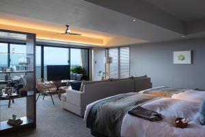 a bedroom with a large bed and a living room at Glamday Style Okinawa Yomitan Hotel & Resort in Yomitan
