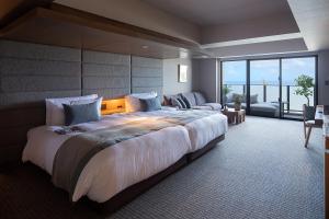 a large bedroom with a large bed and a couch at Glamday Style Okinawa Yomitan Hotel & Resort in Yomitan