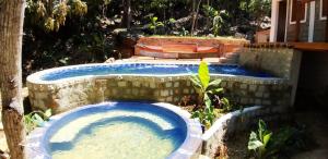 a pool of water in a yard with a tree at Villa King Komba in Nosy Komba