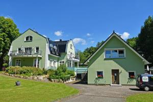 a green and white house with a car parked in front at Gutshaus_Appartements mit Kamin_ S in Coldevitz