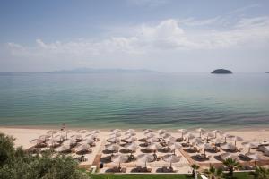 a group of umbrellas and chairs on a beach at Akti Hotel Kavala in Paleo Tsifliki