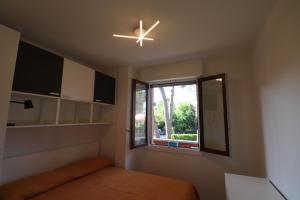 a bedroom with a ceiling fan and a window at La Zagara Bibione, near beach in Bibione
