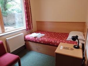 a small bedroom with a bed and a window at St John's College in Durham +3 photos