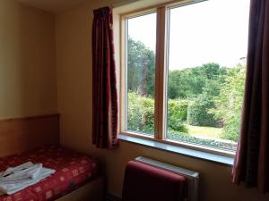 a room with a bed and a large window at St John's College in Durham
