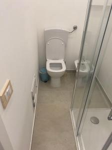a bathroom with a toilet and a glass shower stall at Marilyn Home in Palermo +2 photos