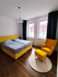 sypialnia z żółtym łóżkiem i krzesłem w obiekcie Ferienhaus Zur alten Korbmacherei w mieście Freyburg +50 zdjęć