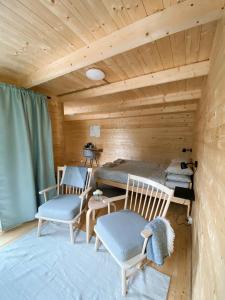 a room with two chairs and a bed in a cabin at Taevaskoja Salamaa Camping in Taevaskoja +17 photos