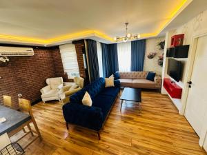 ein Wohnzimmer mit einem blauen Sofa und einem Tisch in der Unterkunft Royal Loft Suit in Antalya