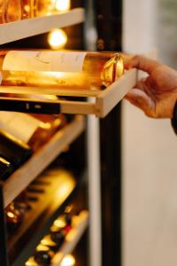 a person holding a bottle of wine in an oven at Paros Agnanti Resort & Spa in Parikia