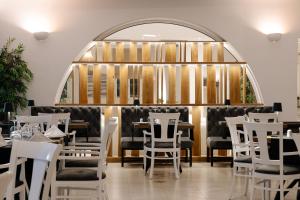 a restaurant with white chairs and tables and a window at Paros Agnanti Resort & Spa in Parikia