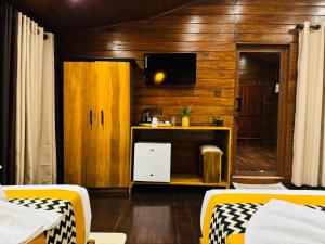 a room with two beds and a tv and a desk at Hotel River Front in Tissamaharama