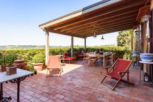a patio with chairs and tables and a wooden pergola at Villa D'Agnola by Mmega in San Casciano in Val di Pesa +37 photos
