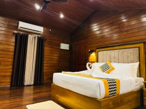 a bedroom with a bed in a wooden wall at Hotel River Front in Tissamaharama