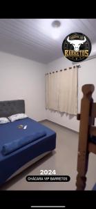a bedroom with a bed and a sign on the wall at Chácara Vip in Barretos