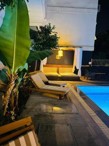 eine Terrasse mit einem Sofa und einem Pool in der Unterkunft Royal Loft Suit in Antalya