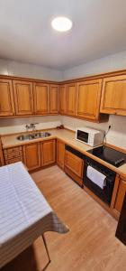 Una cocina con gabinetes de madera y un horno de estufa. en Los Tres Mallos, en Islallana