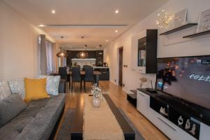 a living room with a couch and a large television at Hyggemate - 2 Bed Room Warm Stay in Sarnitsa in Sarnitsa