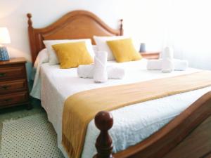 a bedroom with two beds with white sheets and yellow pillows at Alojamiento Caldas Centro in Caldas de Reis +28 photos
