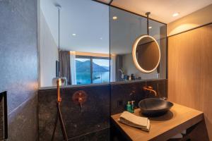 un bagno con lavandino e specchio di Exclusive Boutique Hotel Elisabetta a Ronco sopra Ascona