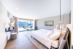una camera da letto con un letto e una grande finestra di Exclusive Boutique Hotel Elisabetta a Ronco sopra Ascona