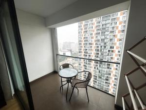 a balcony with a table and two chairs and a large window at Apartamento dúplex exclusivo y céntrico in Lima