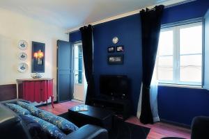 uma sala de estar azul com um sofá e uma televisão em InnLisbon Apartment em Lisboa