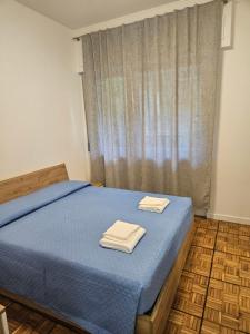 a bedroom with a blue bed with two towels on it at Appartamento Sole e Mare Rapallo 4 in Rapallo