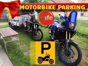 Zwei Motorräder parkten im Gras neben einem Schild. in der Unterkunft Dream in Drvar