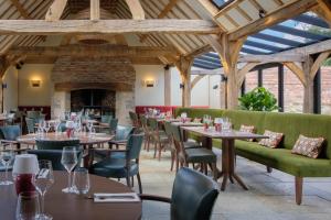 a dining room with tables and chairs and a fireplace at Boys Hall in Willesborough