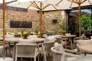 a restaurant with tables and chairs and a brick wall at Boys Hall in Willesborough