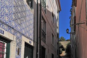 un vicolo con piastrelle bianche e blu sul lato di un edificio di InnLisbon Apartment a Lisbona