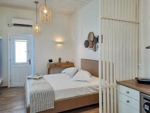 a white bedroom with a bed and a kitchen at Boufounis Studios in Kamares