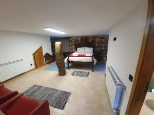 a bedroom with a bed and a stone wall at Fuinhas de Amor in Fornos de Algodres