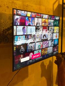 カイロにあるستوديو هادئ ومريحの壁にたくさんの映画が映し出されたテレビ画面