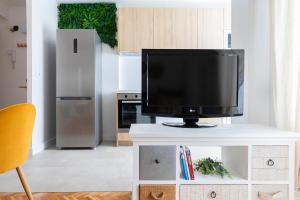 a television on a white table in a kitchen at Casa Bombón in Sabiñánigo